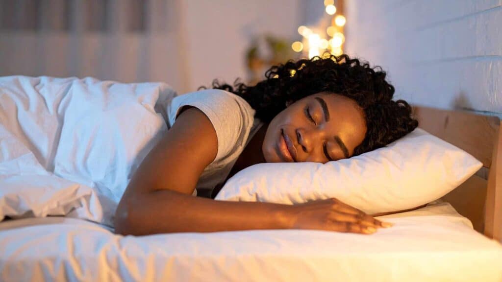 Personne dormant profondément la nuit dans une chambre calme favorisant un sommeil paradoxal réparateur